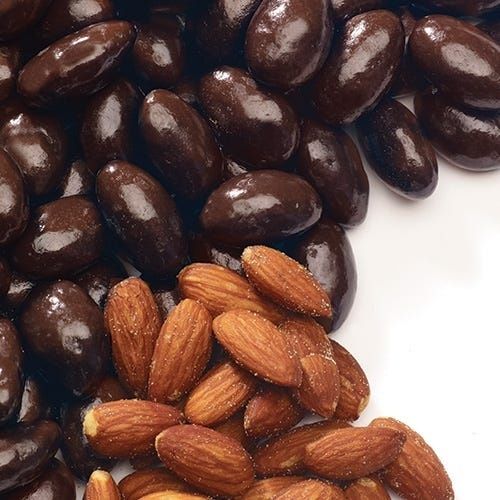Amandes entières et amandes enrobées de chocolat noir sur fond blanc